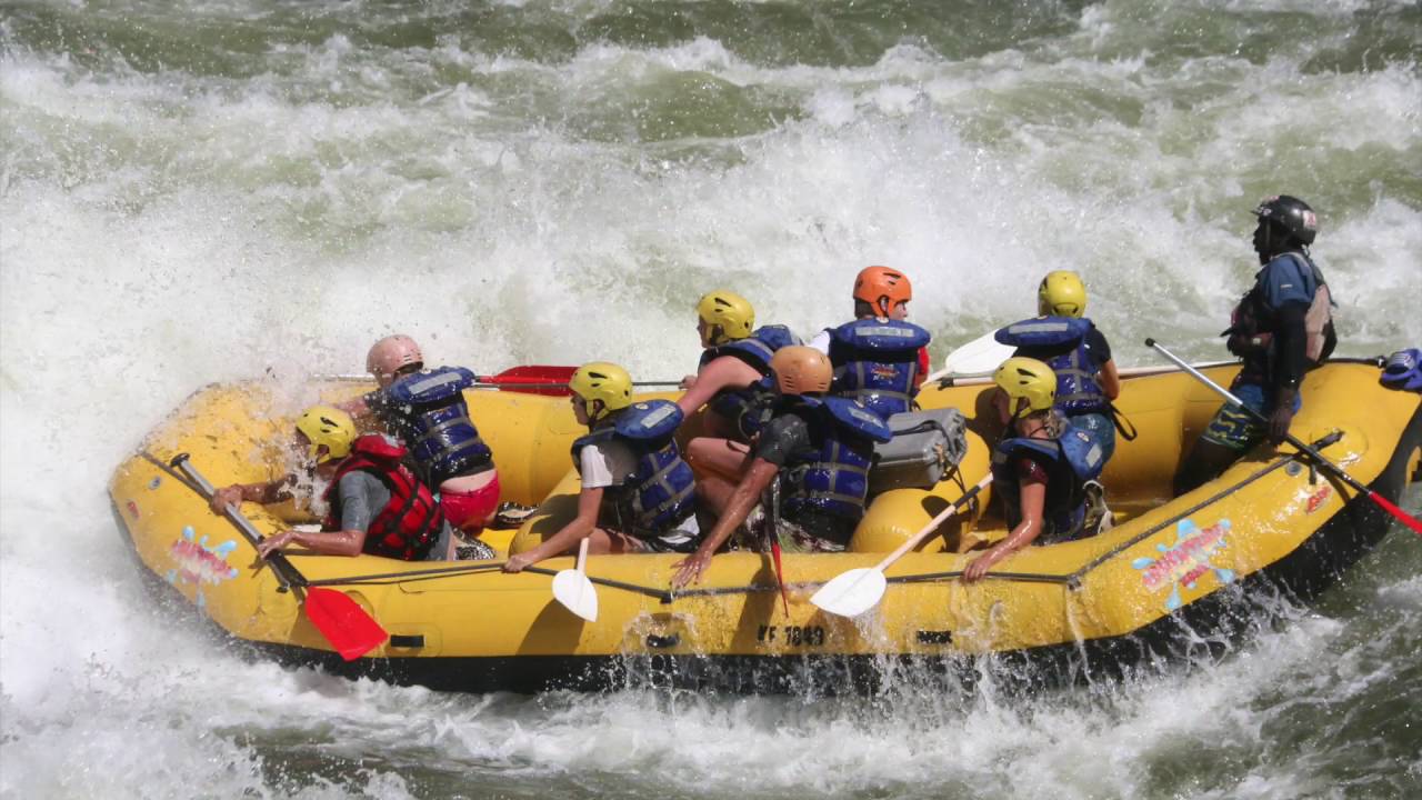 A raft full of paddlers punching through a big white water rapid on the Zambezi River below Victoria Falls